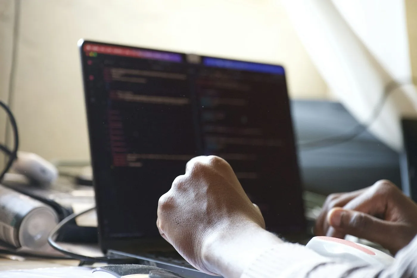A developer typing on a laptop.