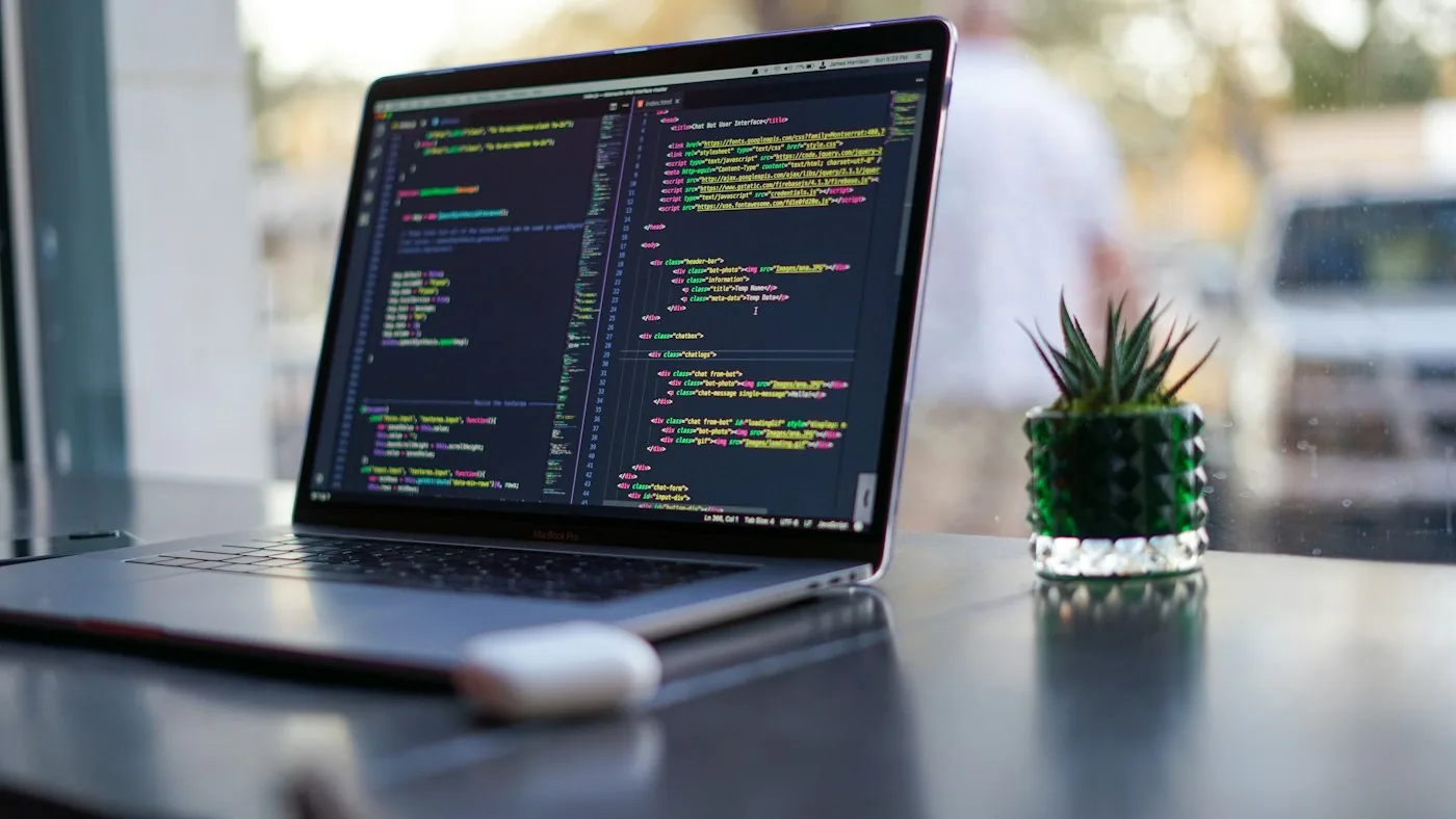 A laptop showing code in a bright workspace.