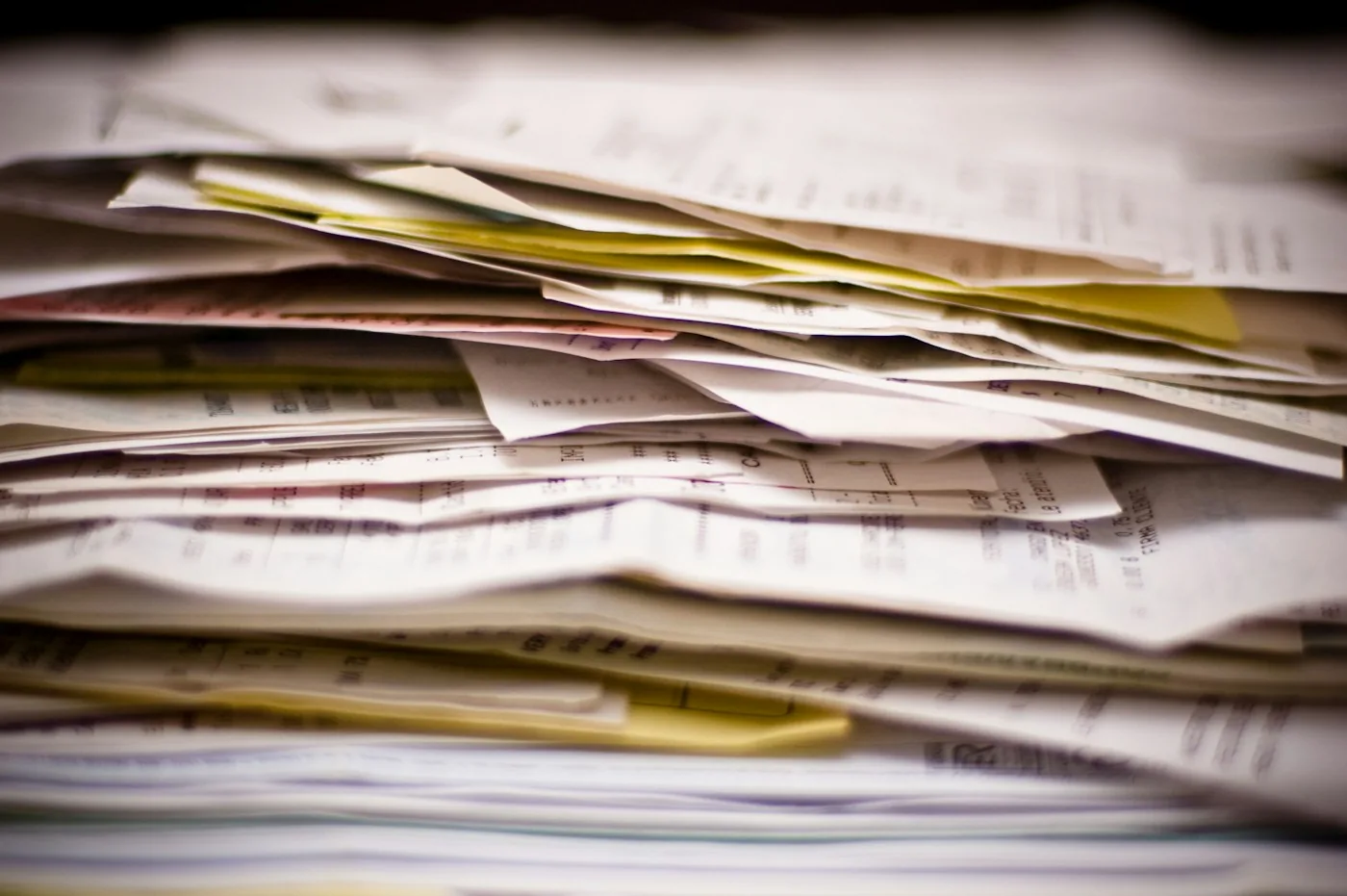 A backlog of stacked paper documents.