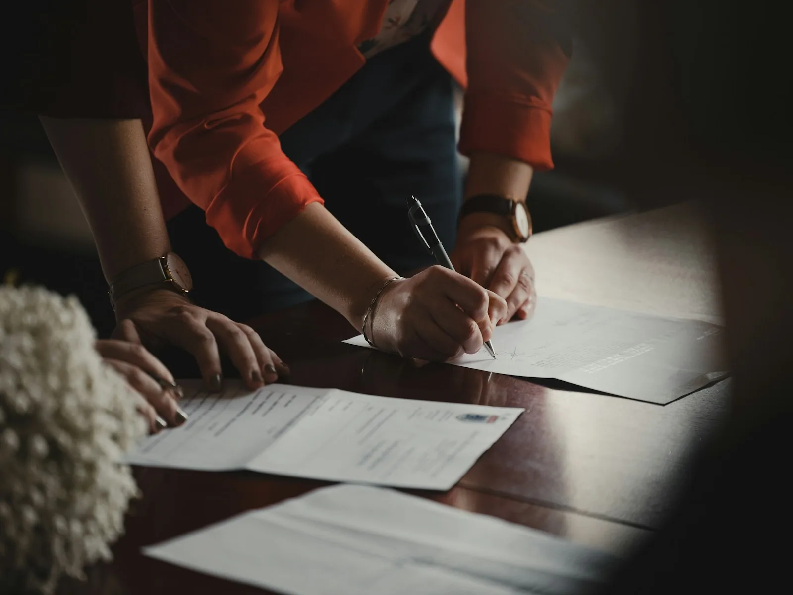 Professionals reviewing and signing business documents.