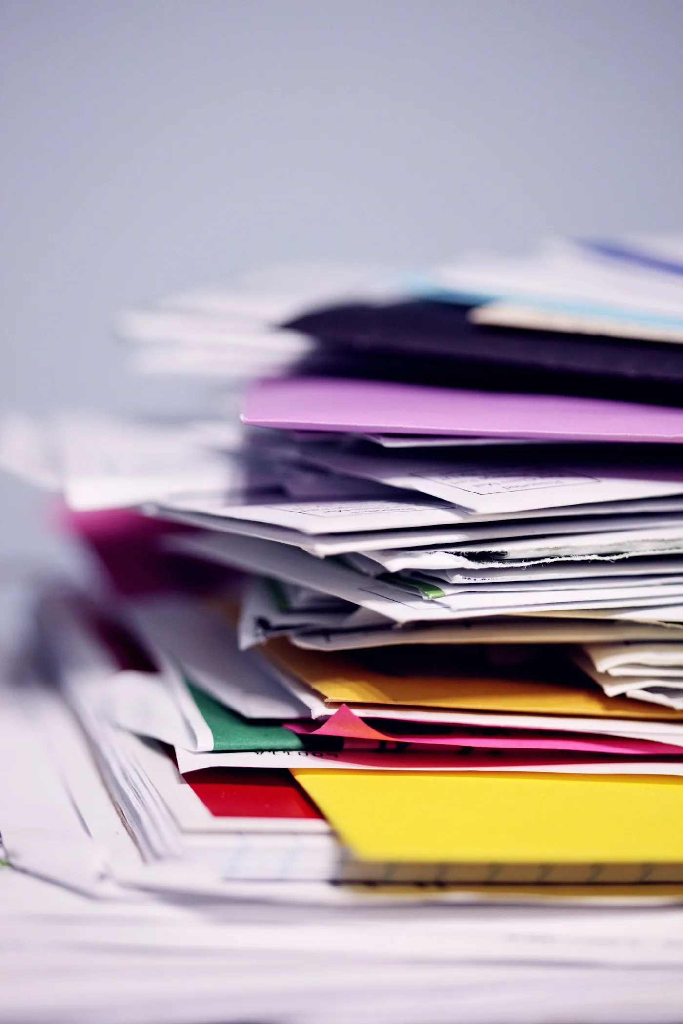Paper documents and folders stacked for processing.