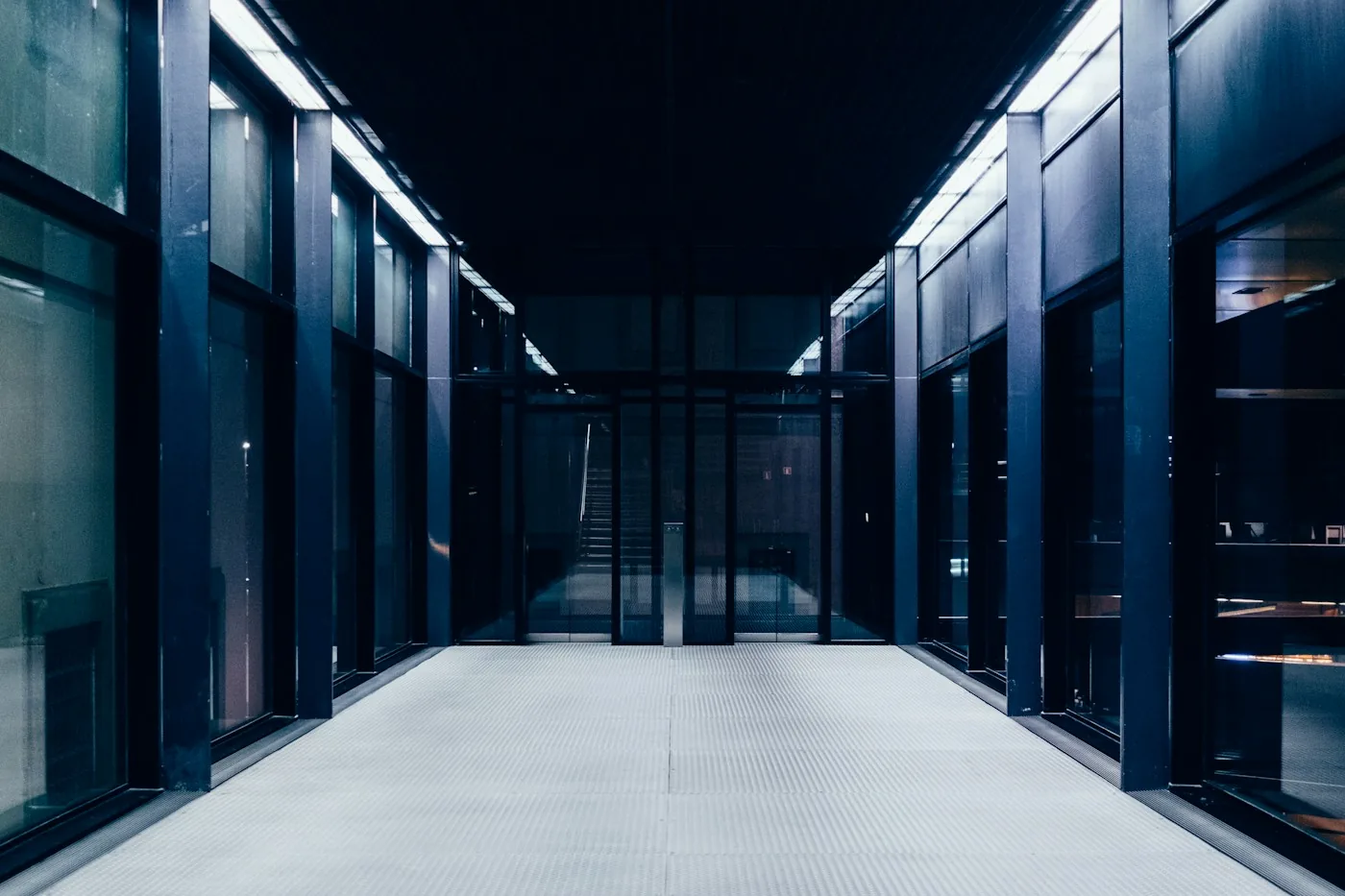 An illuminated aisle between data-center server rooms.