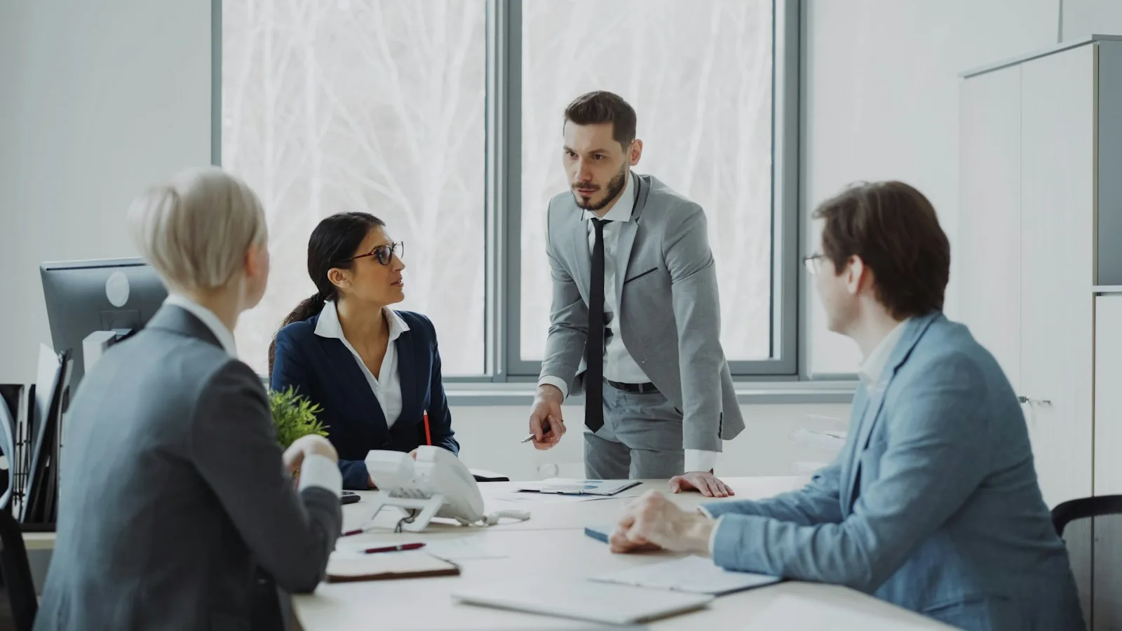 Business professionals discussing plans around a table.
