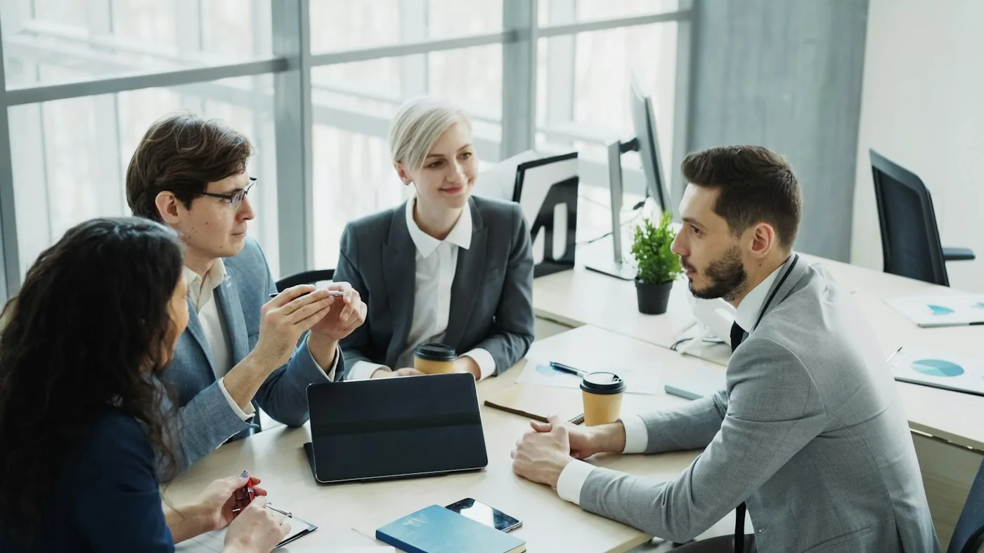 A diverse team discussing a project around a tablet.