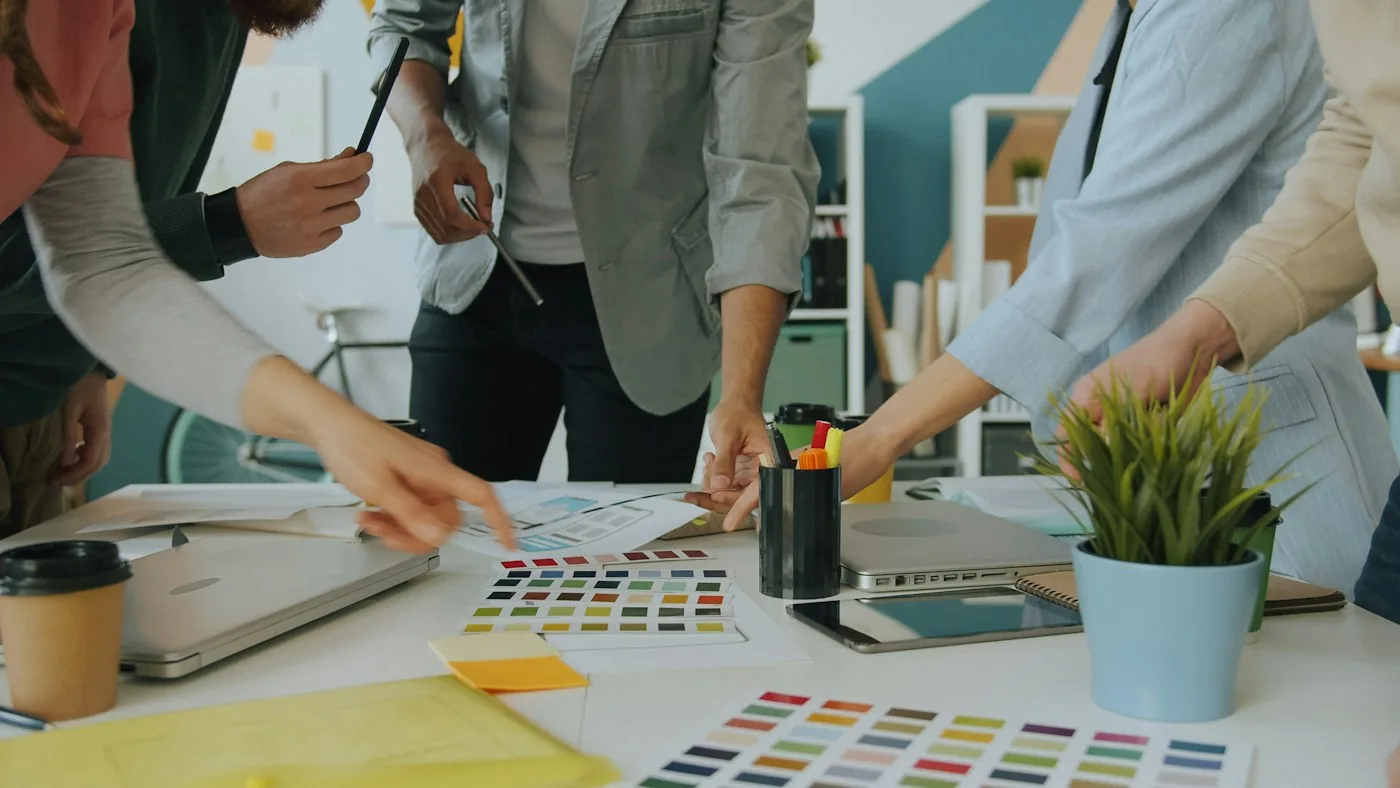 A team reviewing interface designs and color samples.