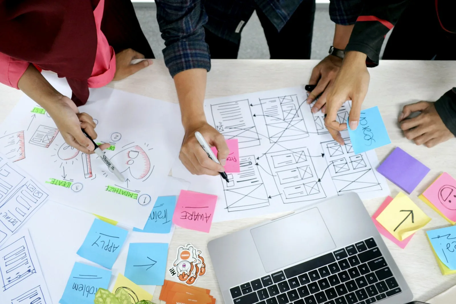 Designers mapping application workflows with sketches and notes.