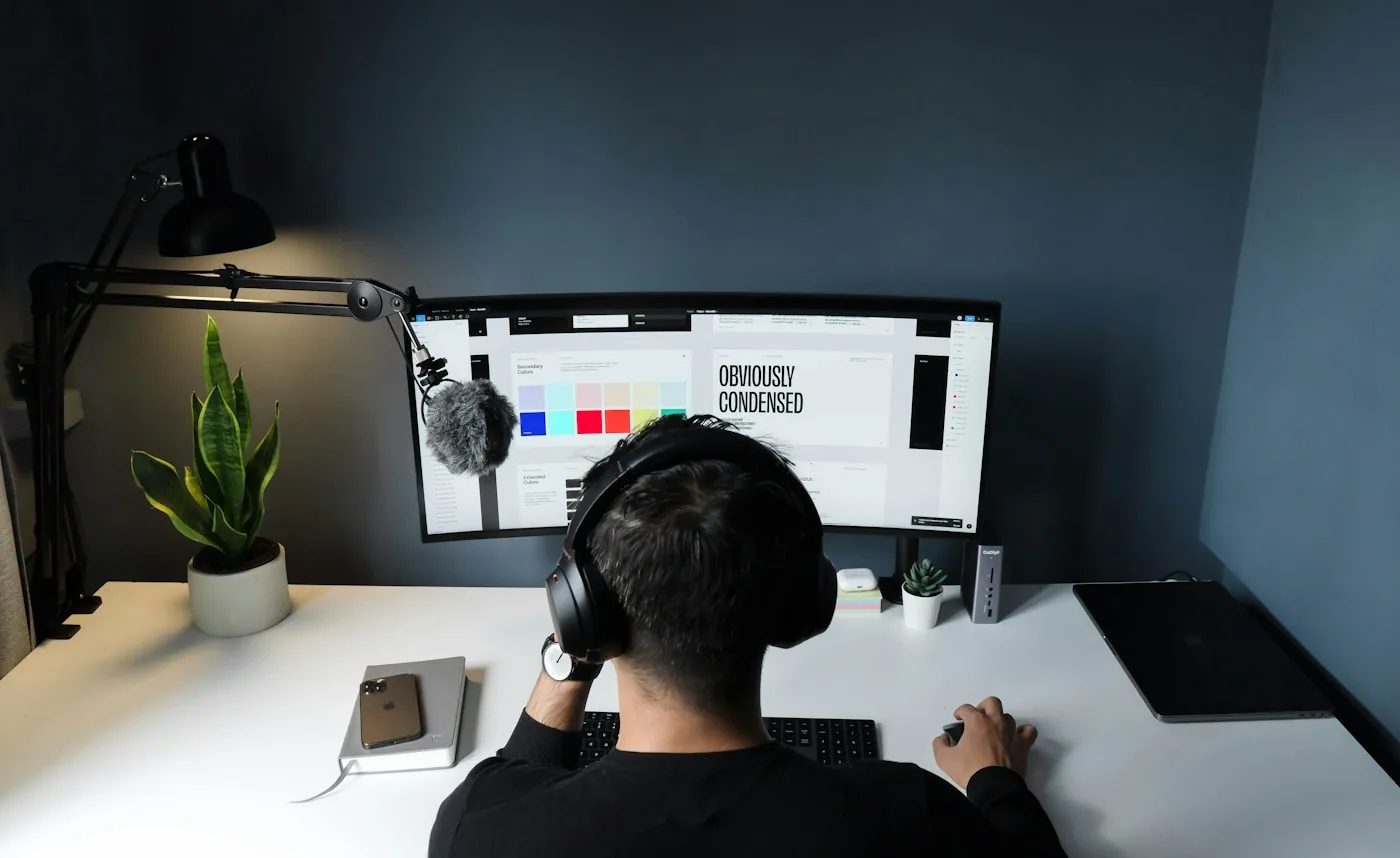 A product designer reviewing interface screens at a workstation.