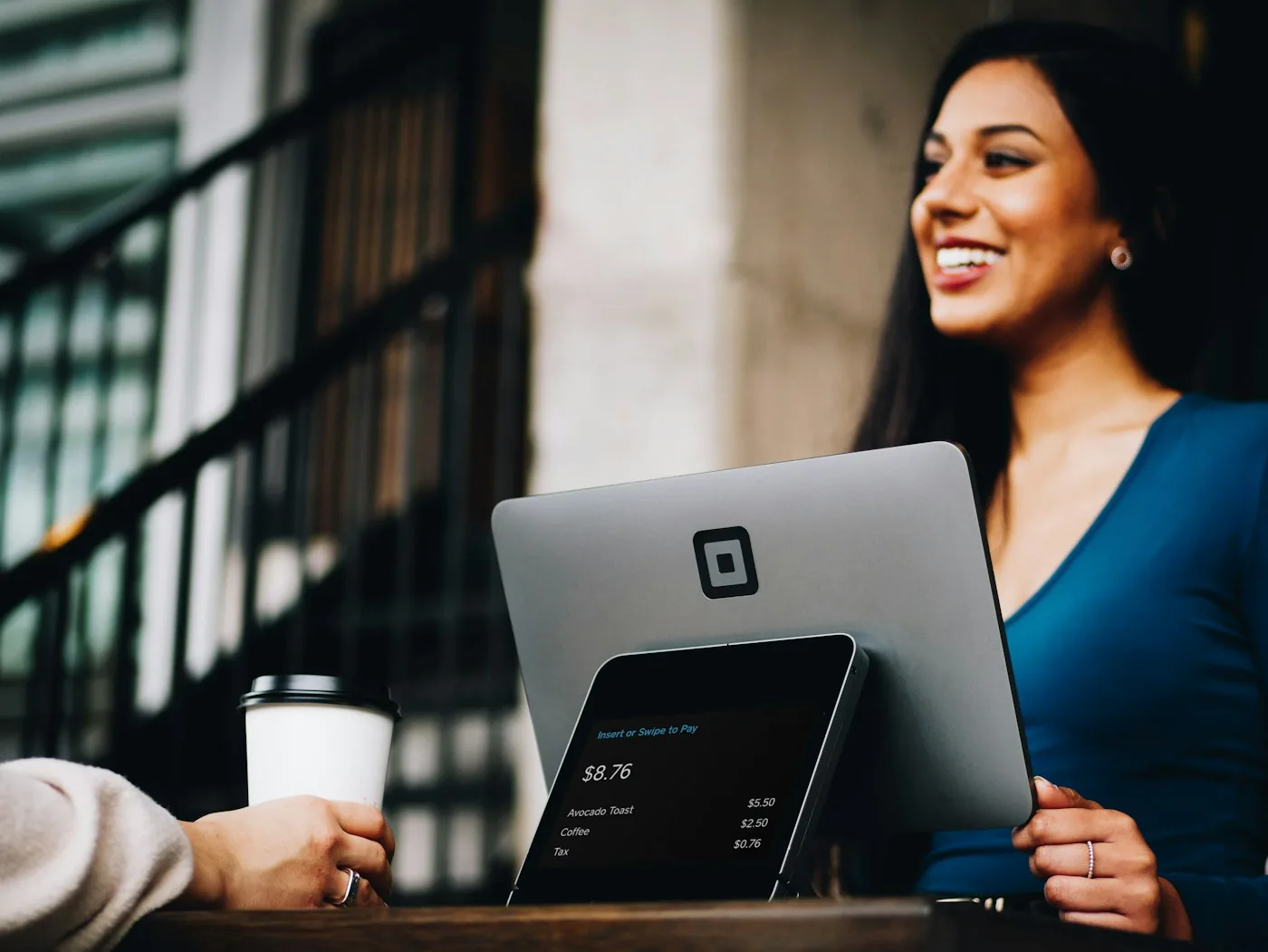 A business professional interacting with a customer at a terminal.