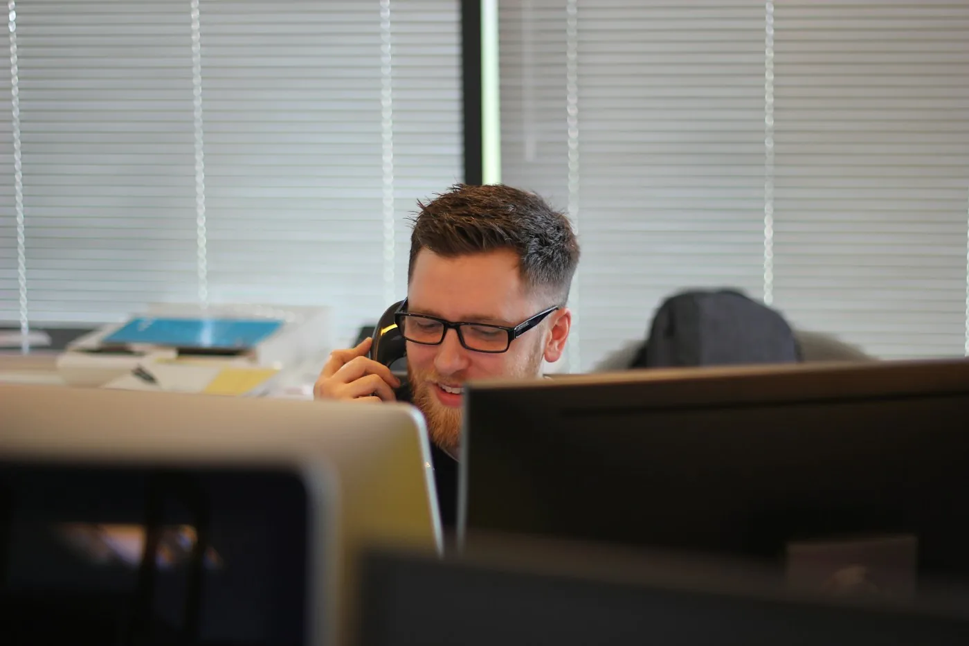 A support professional using a desk phone and computer.