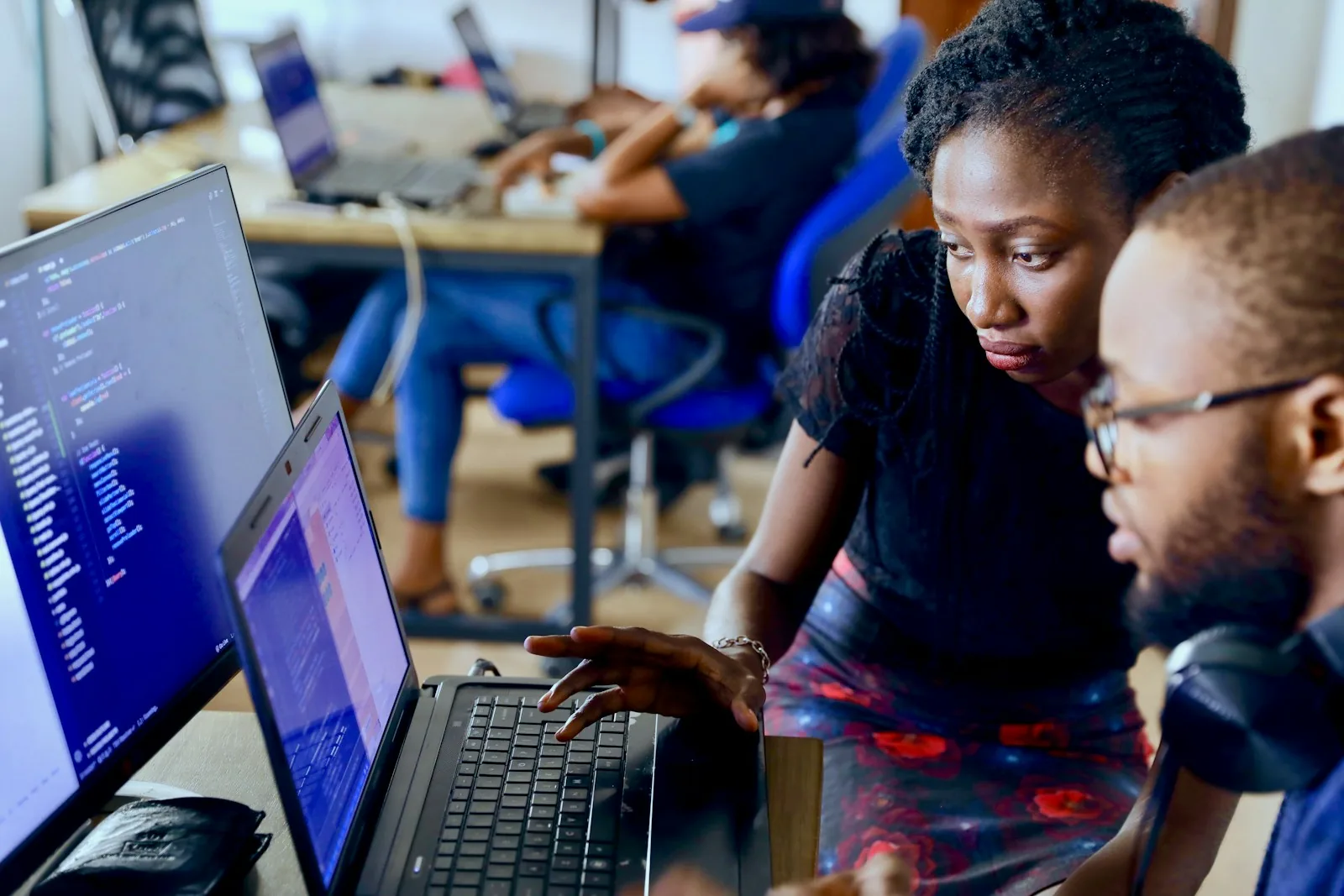Colleagues reviewing source code together on a laptop.