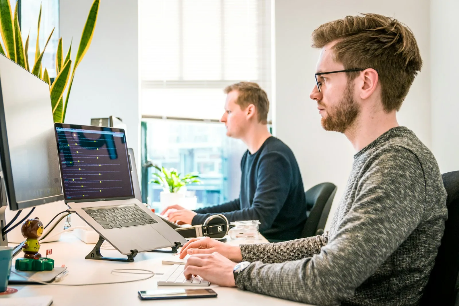 Developers working at adjacent computer workstations.