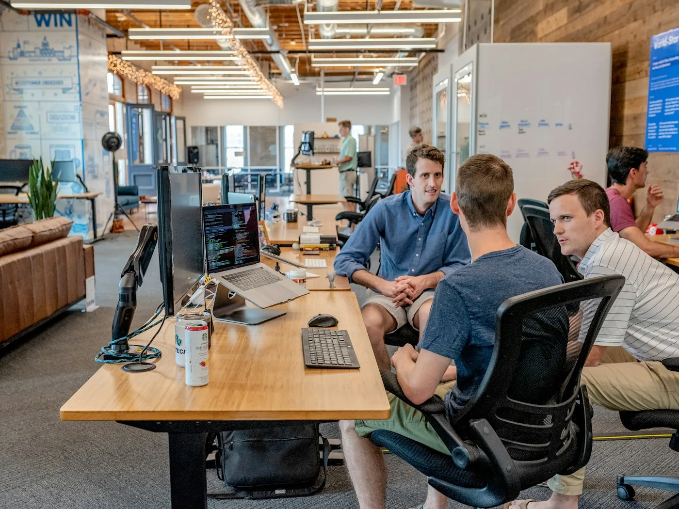 An engineering team meeting at a shared office desk.